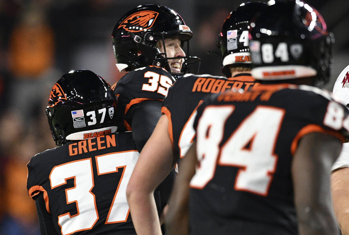 Oregon State place kick holder Josh Green (37) hugs place kicker Everett Hayes (35) after the g ...