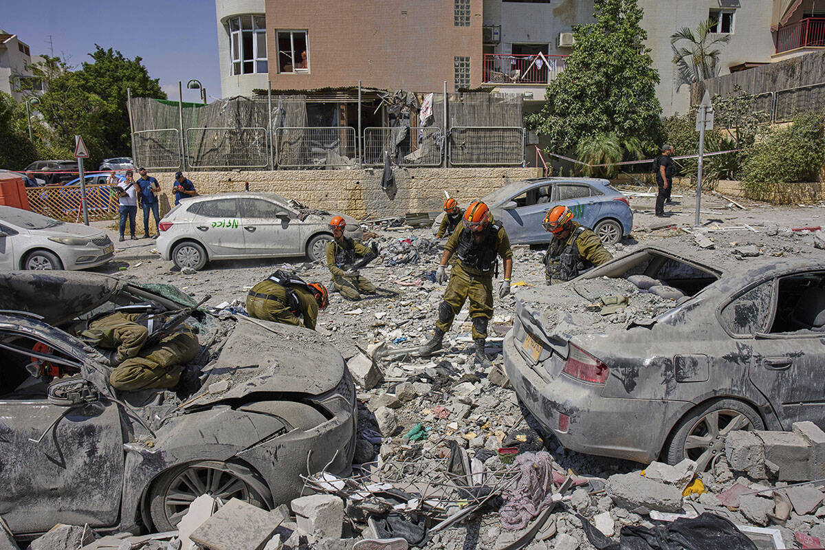 Israeli soldiers work amid the rubble of residential buildings destroyed by an Iranian missile ...