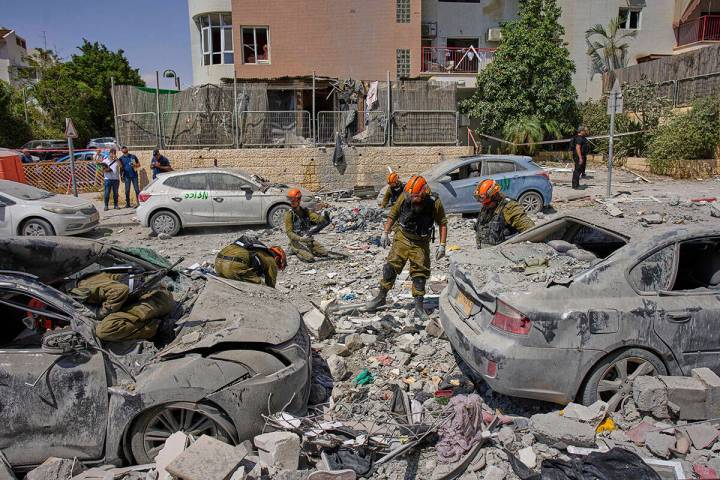 Israeli soldiers work amid the rubble of residential buildings destroyed by an Iranian missile ...