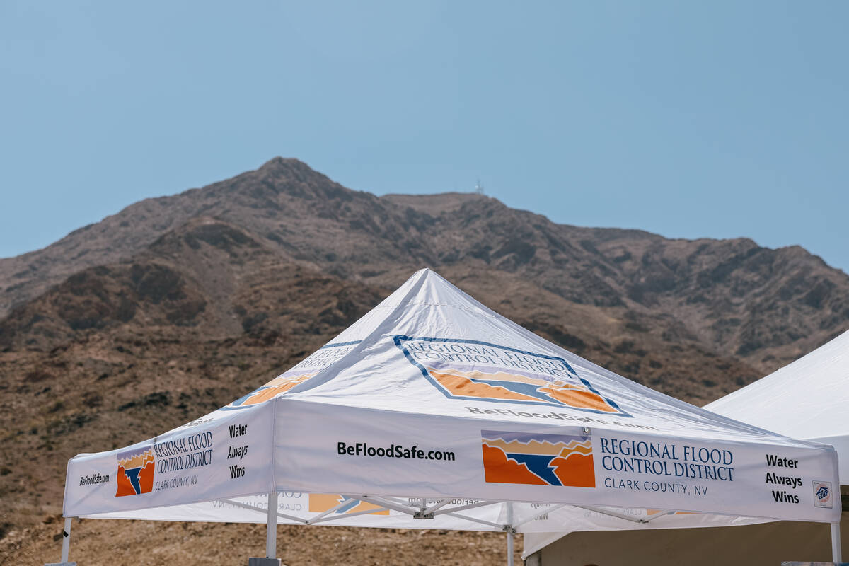 A Regional Flood Control District tent provides shade for attendees of a press conference about ...