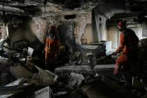 Workers clear rubble of a damaged building, in Tehran, Iran, Wednesday, June 25, 2025, after an ...