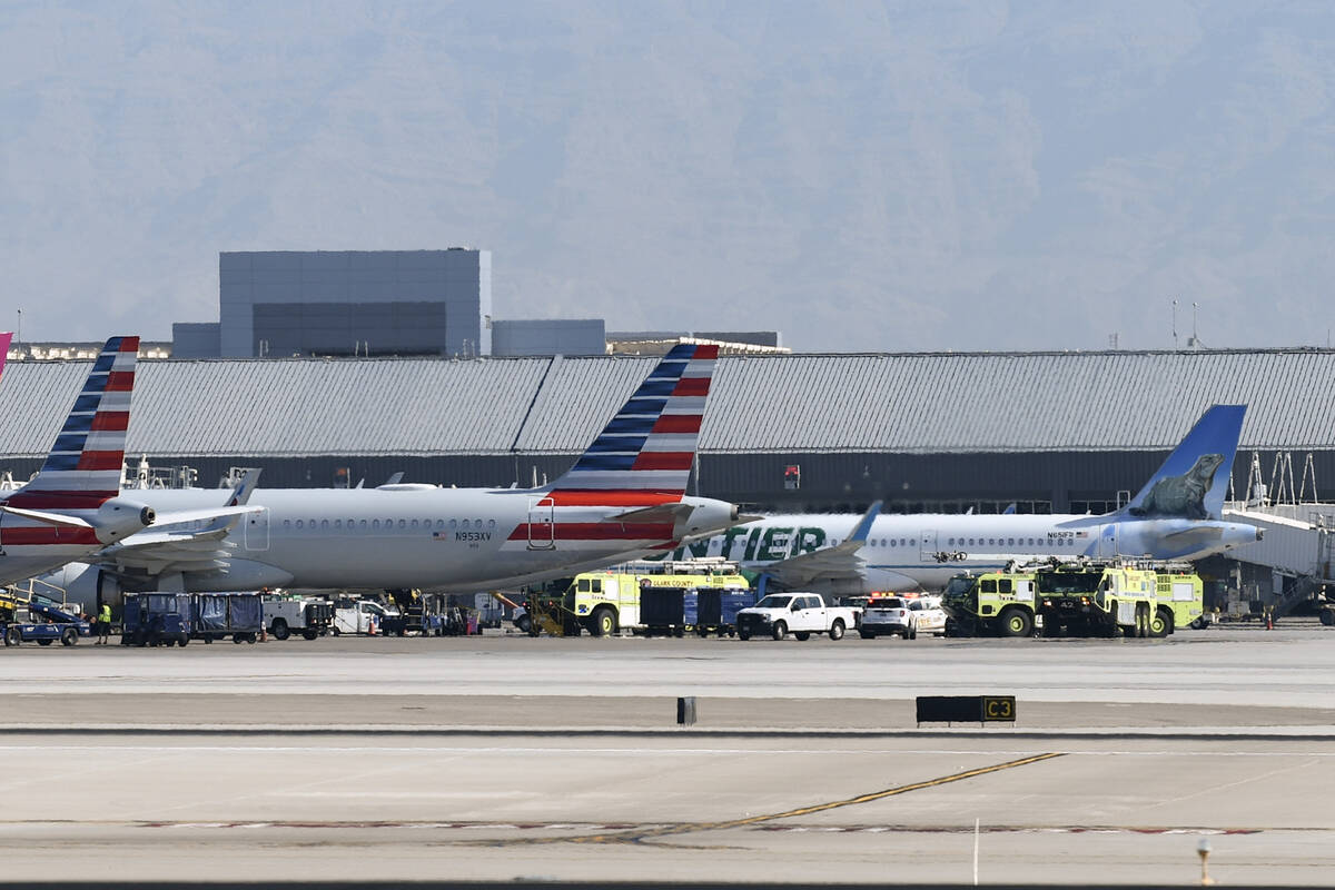 Emergency vehicles are seen next to an American Airlines jet upon its return to Harry Reid Inte ...