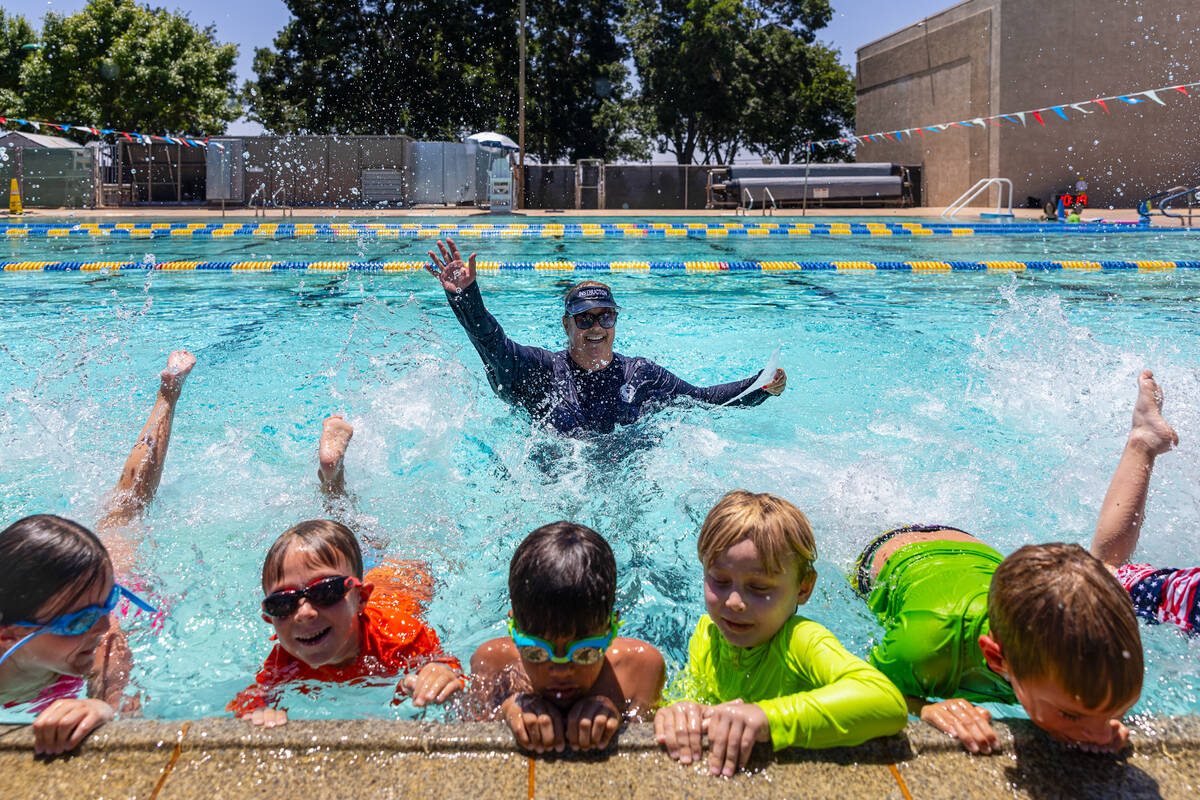 Swim instructor Cheryl Waites, center, motions as children practice their kicking in the water ...