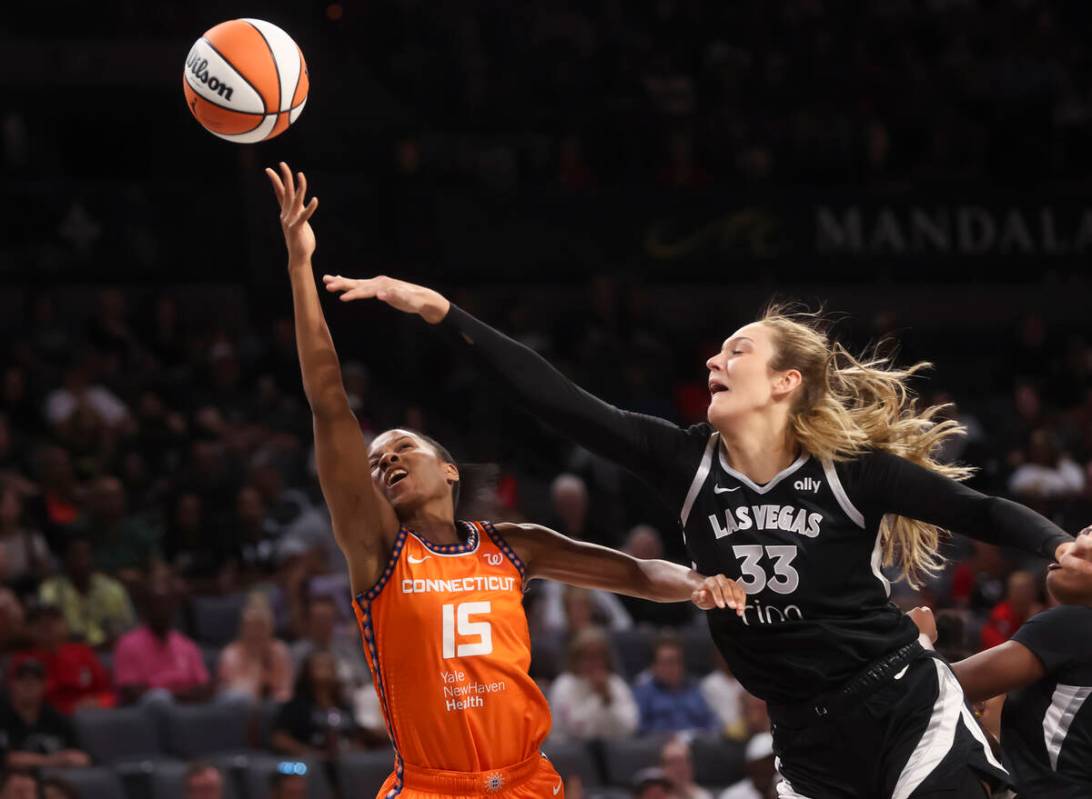 Aces center Elizabeth Kitley (33) defends as Connecticut Sun guard Lindsay Allen (15) lays up t ...