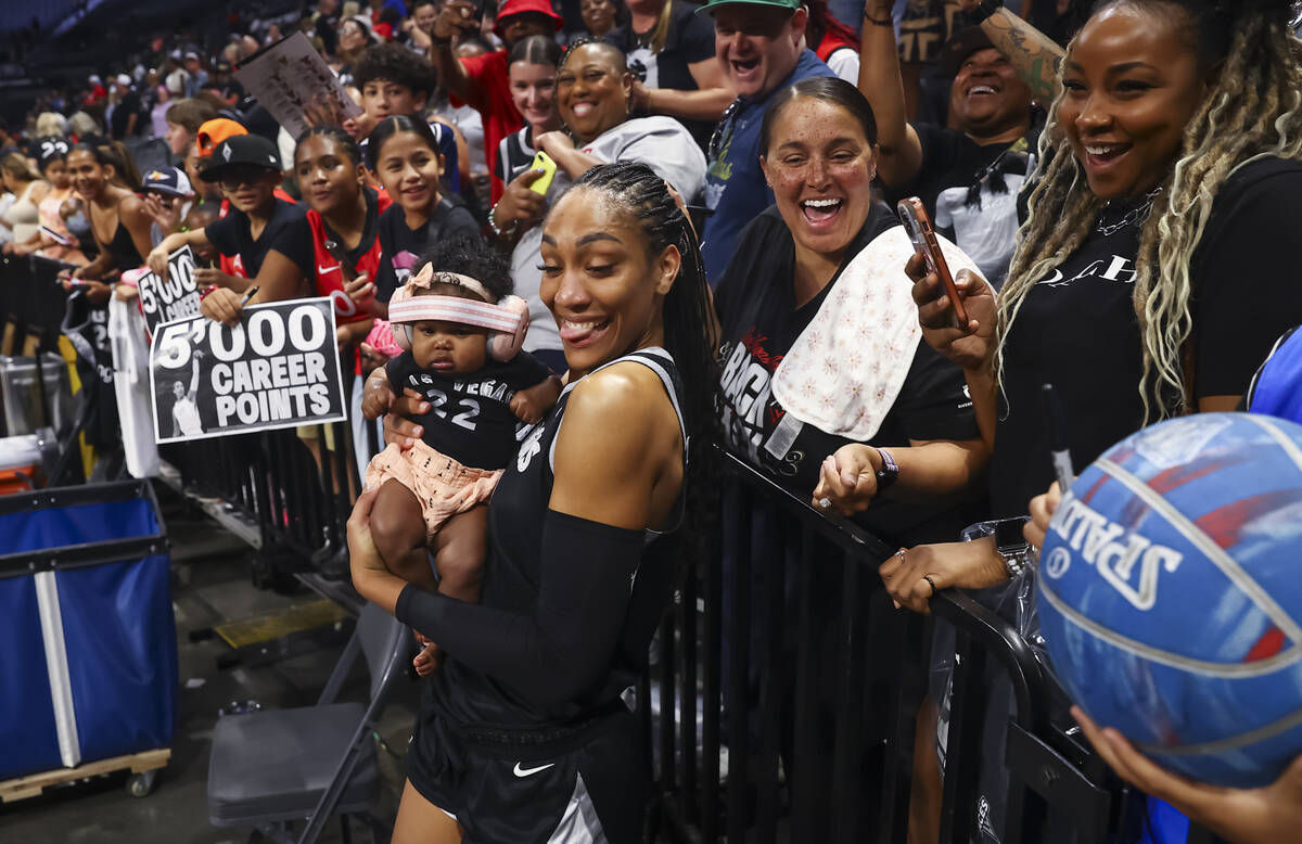 Aces center A'ja Wilson (22) holds a baby from the crowd after defeating the Connecticut Sun in ...