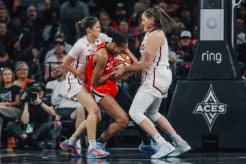 Aces center A'ja Wilson (22) is sandwiched by Washington Mystics defenders during a WNBA game b ...