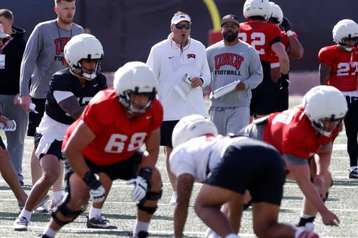 UNLV football offensive line coach Mike Sollenne, left, and head coach Dan Mullen watche their ...