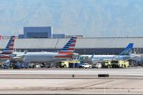 Emergency vehicles are seen next to an American Airlines jet upon its return to Harry Reid Inte ...