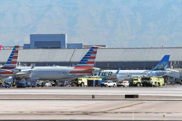 Emergency vehicles are seen next to an American Airlines jet upon its return to Harry Reid Inte ...