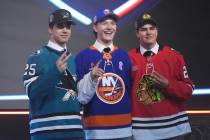Matthew Schaefer, drafted first by the New York Islanders, middle, stands between Michael Misa, ...