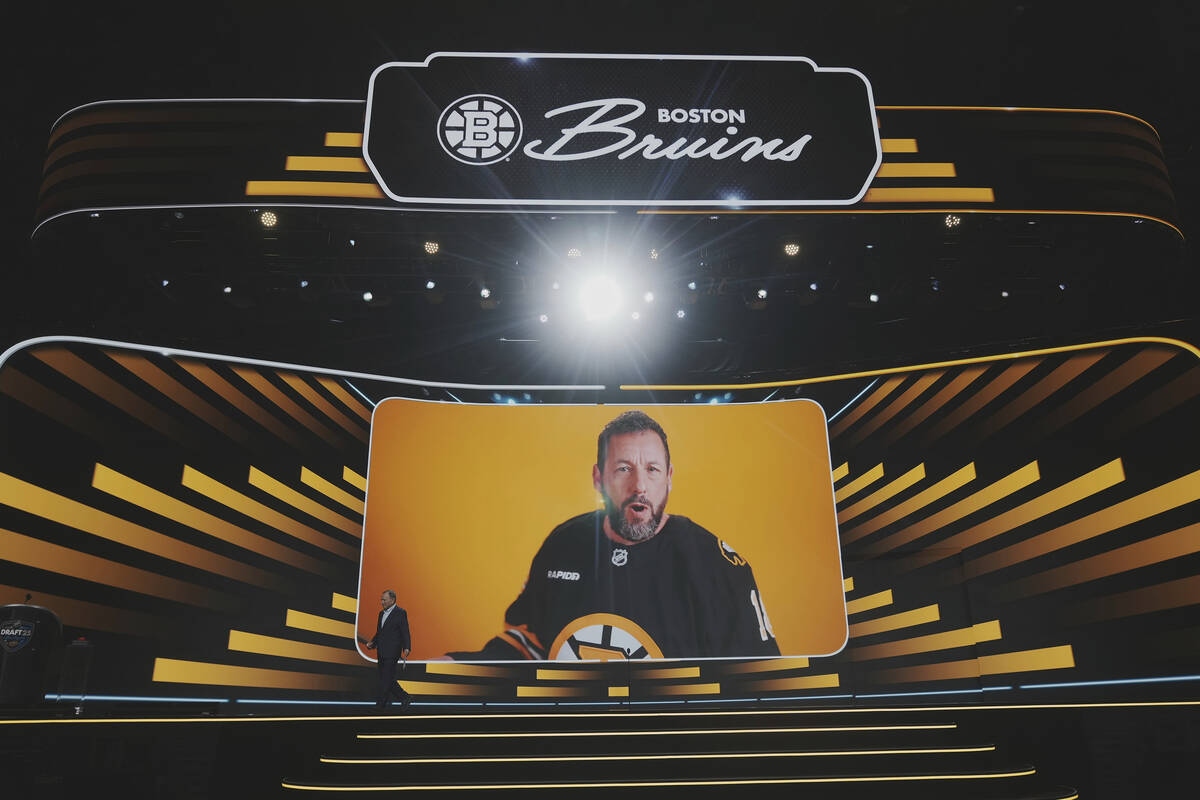 Comedian Adam Sandler appears on the screen behind NHL commissioner Gary Bettman during the NHL ...