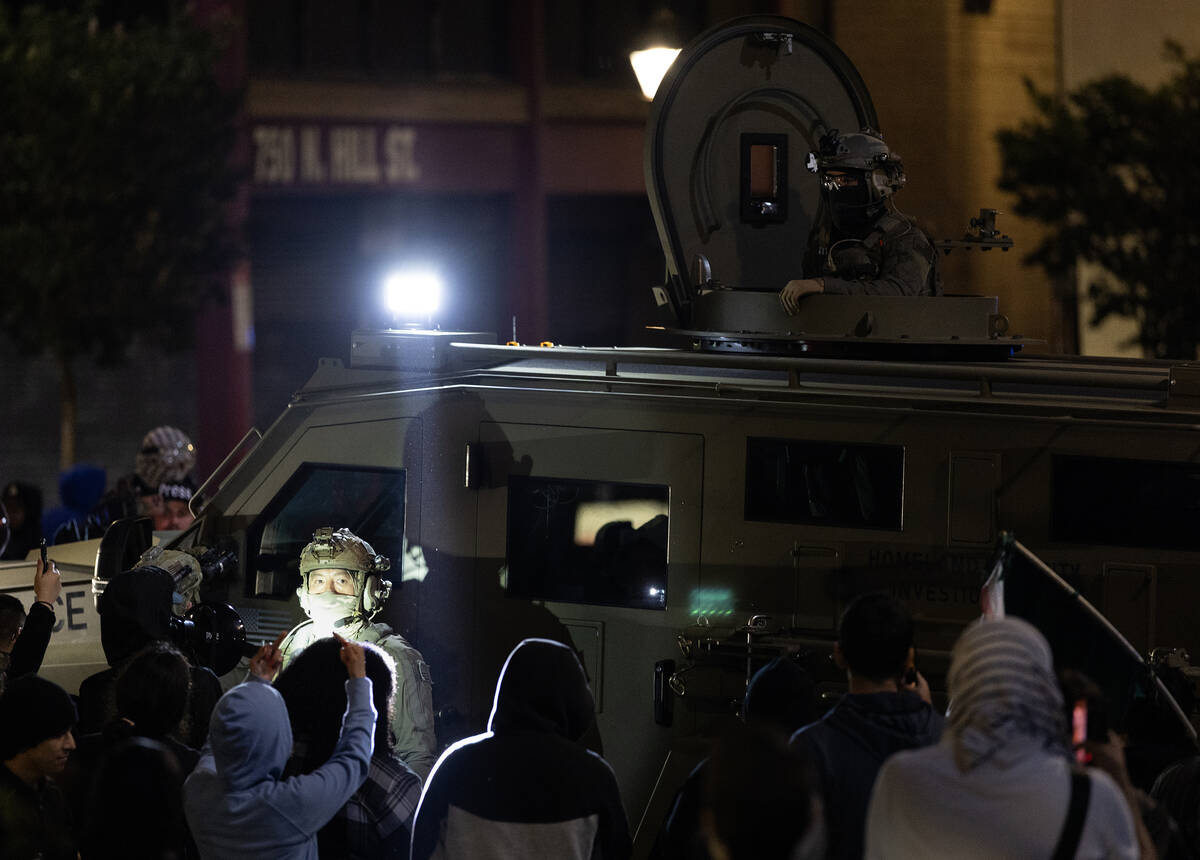 ICE officers try to leave the scene after performing a raid but protesters block their way in C ...