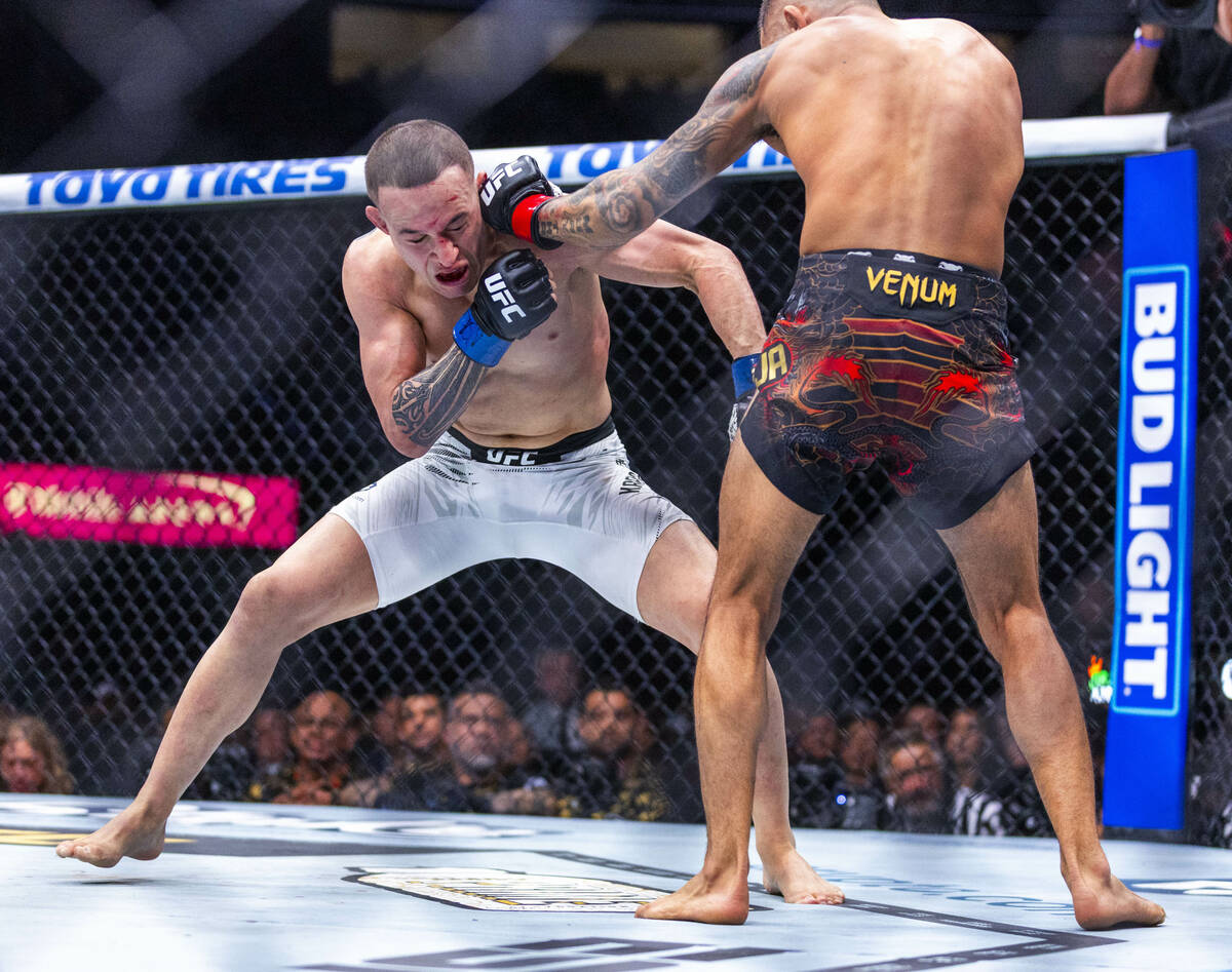 Kai Kara-France takes a strike from Alexandre Pantoja during their flyweight title fight in UFC ...