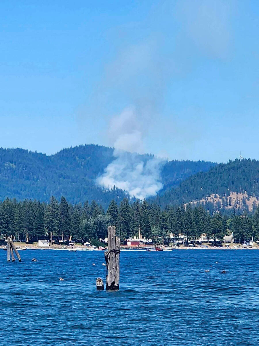 CORRECTS PHOTOGRAPHER Smoke rises from a fire near Lake Coeur d’Alene, Idaho, where resp ...