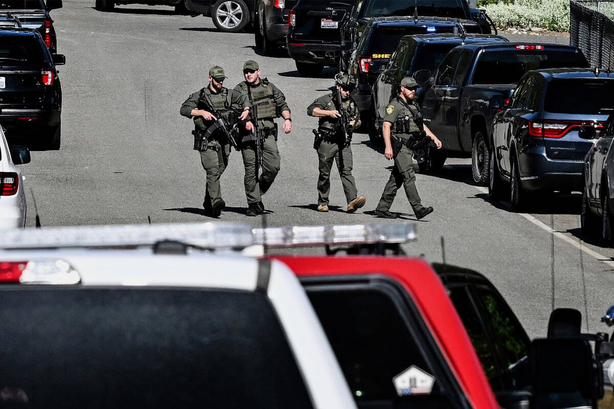 Police and fire crews respond to a shooting and fire on Canfield Mountain in Coeur d'Alene, Ida ...