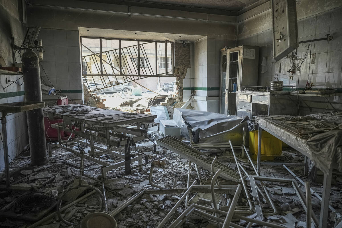 In this photo taken Tuesday, June 24, 2025, rescuers search through the rubble of a damaged sec ...