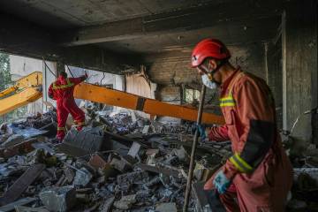 In this photo taken Tuesday, June 24, 2025, rescuers search through the rubble of a damaged sec ...