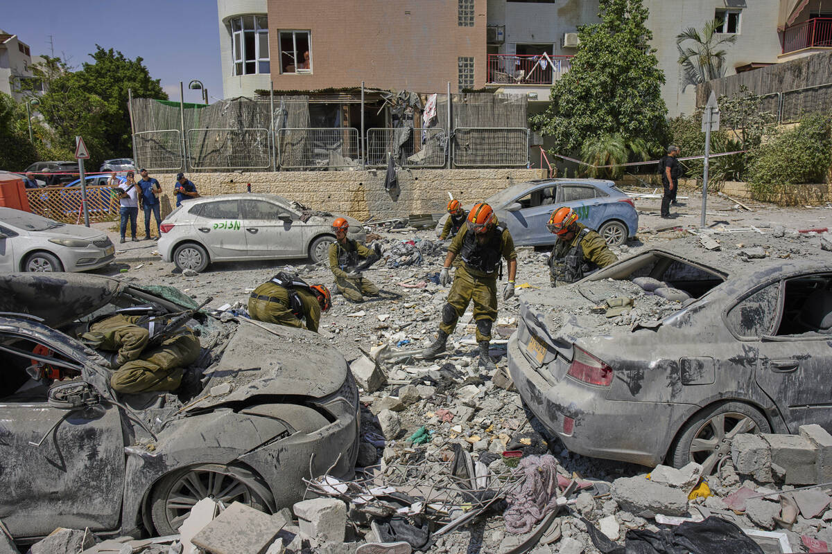 Israeli soldiers work amid the rubble of residential buildings destroyed by an Iranian missile ...