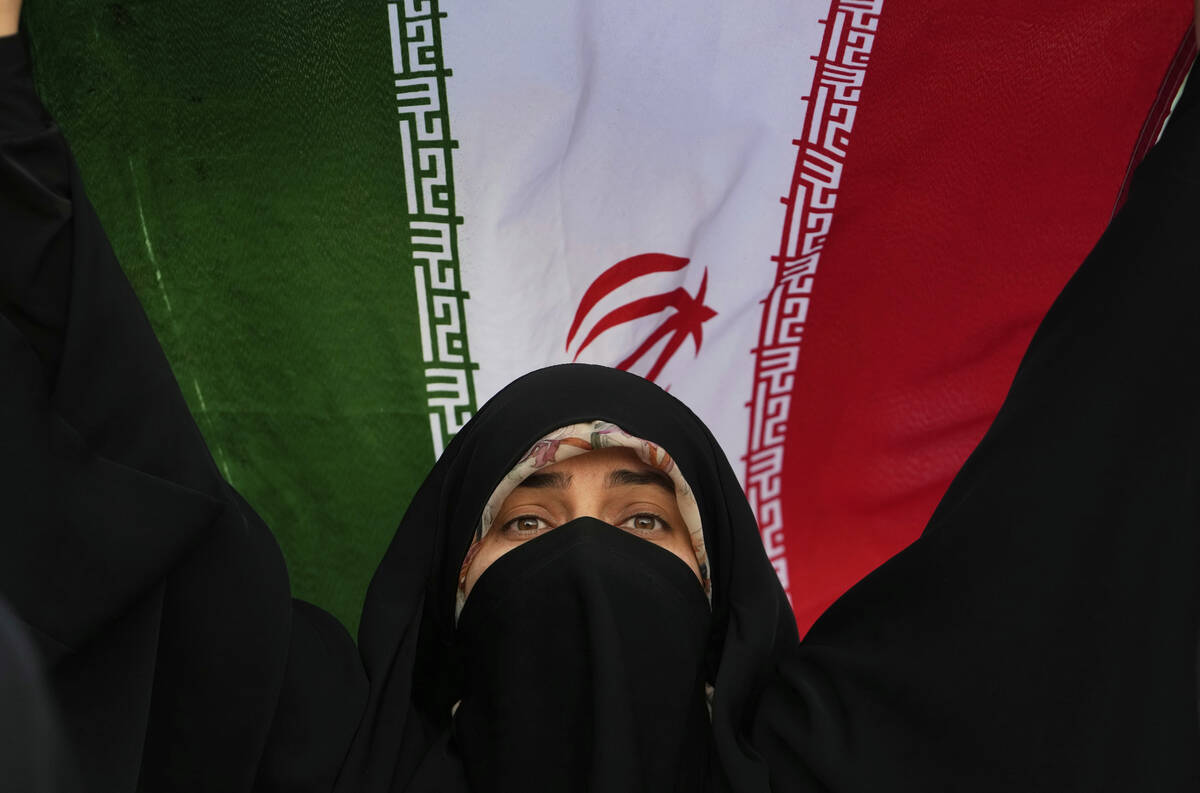 An Iranian woman holds up her country's flag in an anti-U.S. and anti-Israeli rally at Enqelab- ...