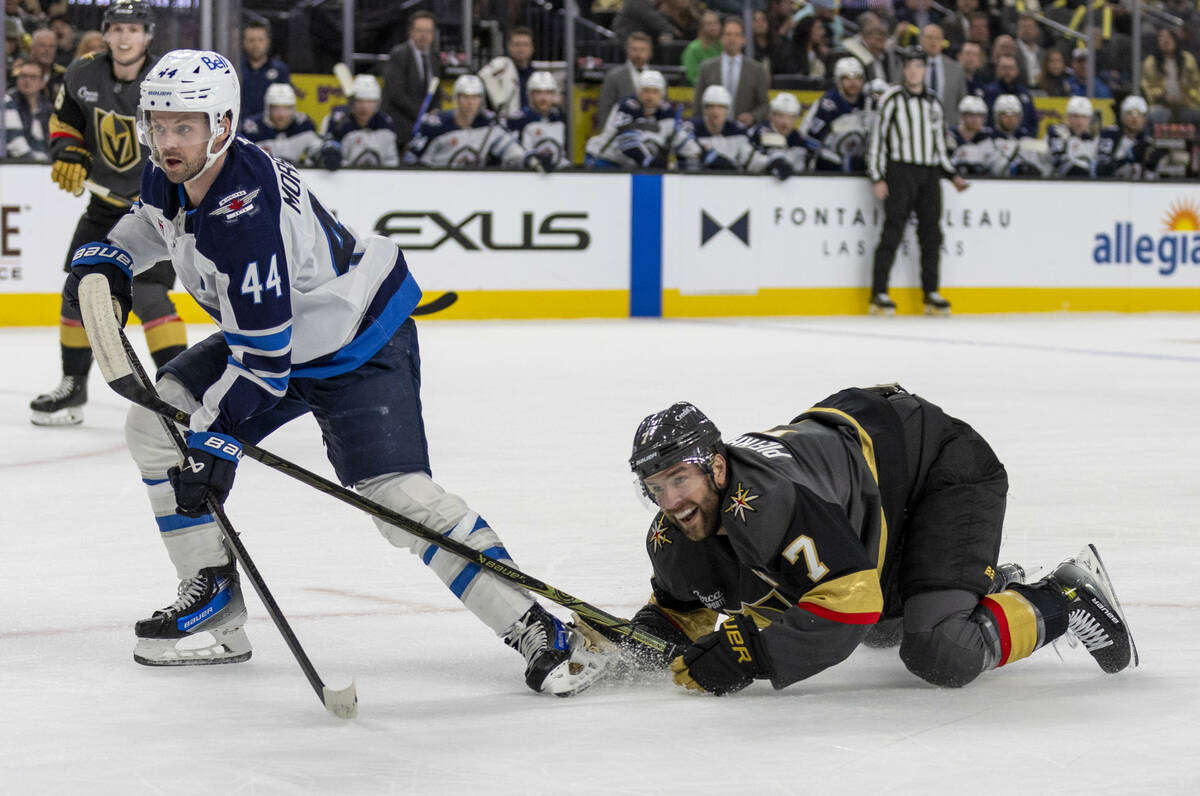 Golden Knights defenseman Alex Pietrangelo (7) goes down as Winnipeg Jets defenseman Josh Morri ...