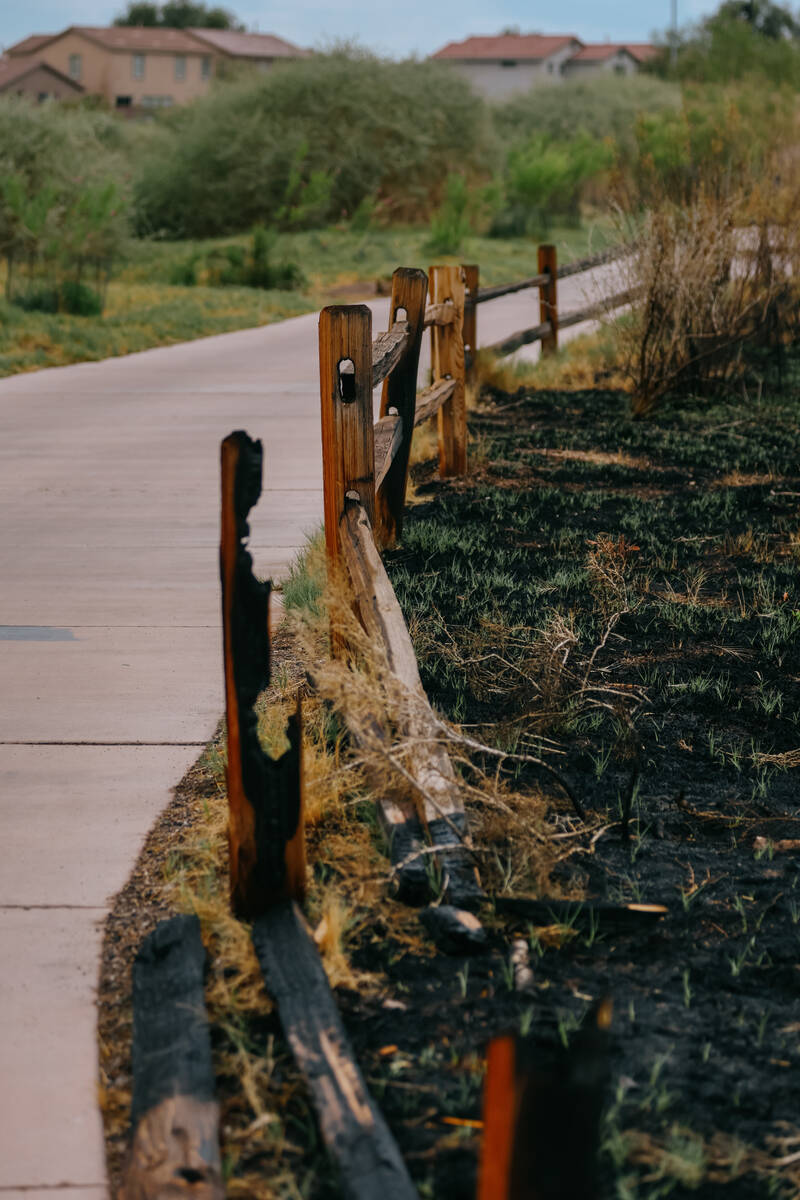 Parts of the trail’s fencing remain standing, while other parts lie in burned pieces at ...