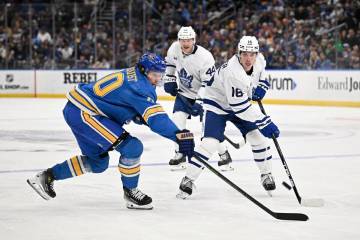 Toronto Maple Leafs' Mitch Marner (16) and St. Louis Blues' Oskar Sundqvist (70), left, reach f ...