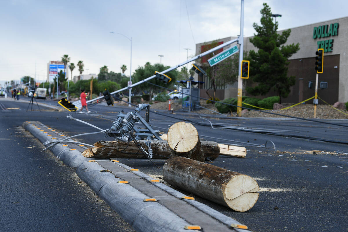 Downed lights and power poles are seen on Tropicana Avenue near McLeod Drive Wednesday, July 2, ...