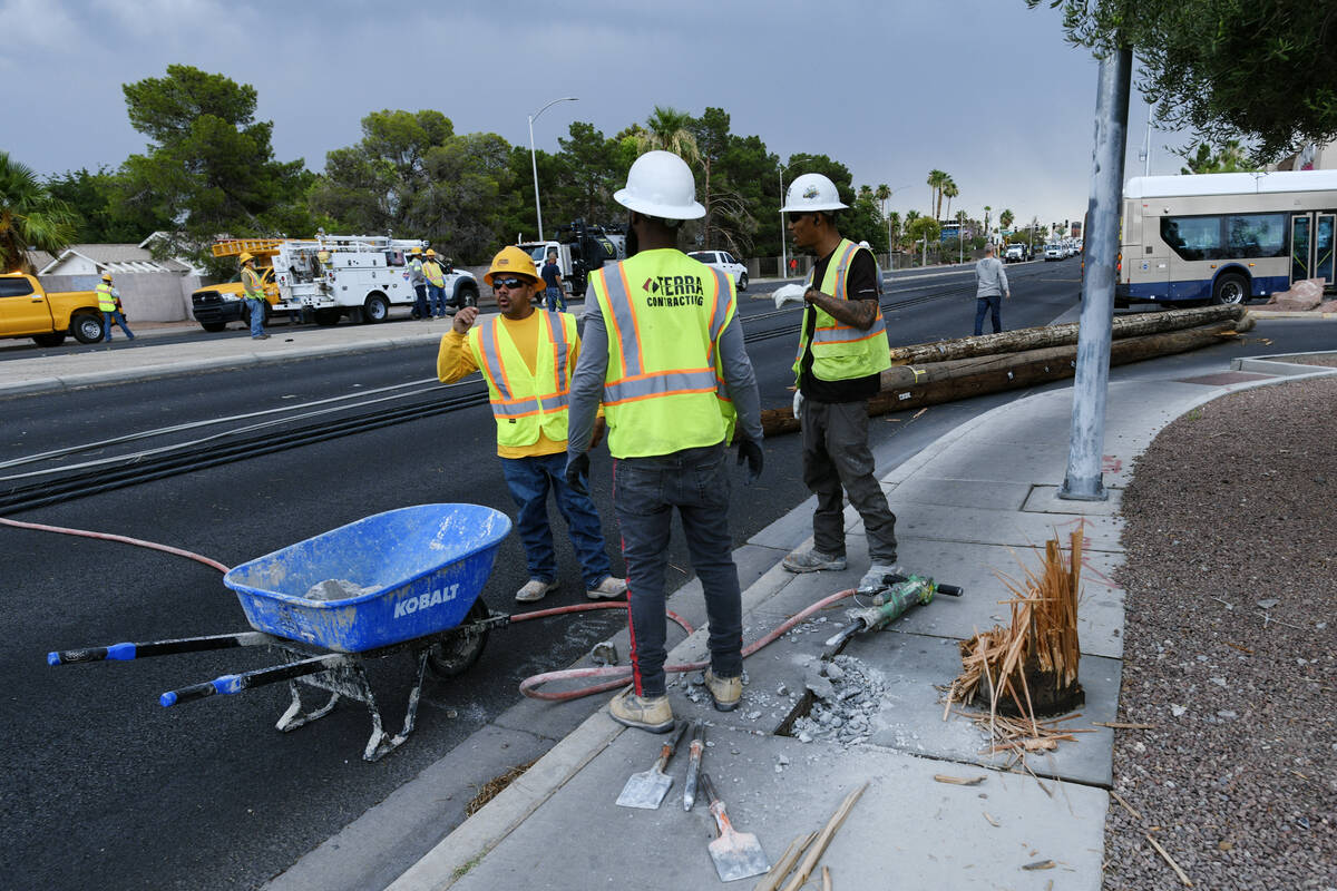 Workers cut out concrete to removed a downed power pole Wednesday, July 2, 2025, on Tropicana A ...