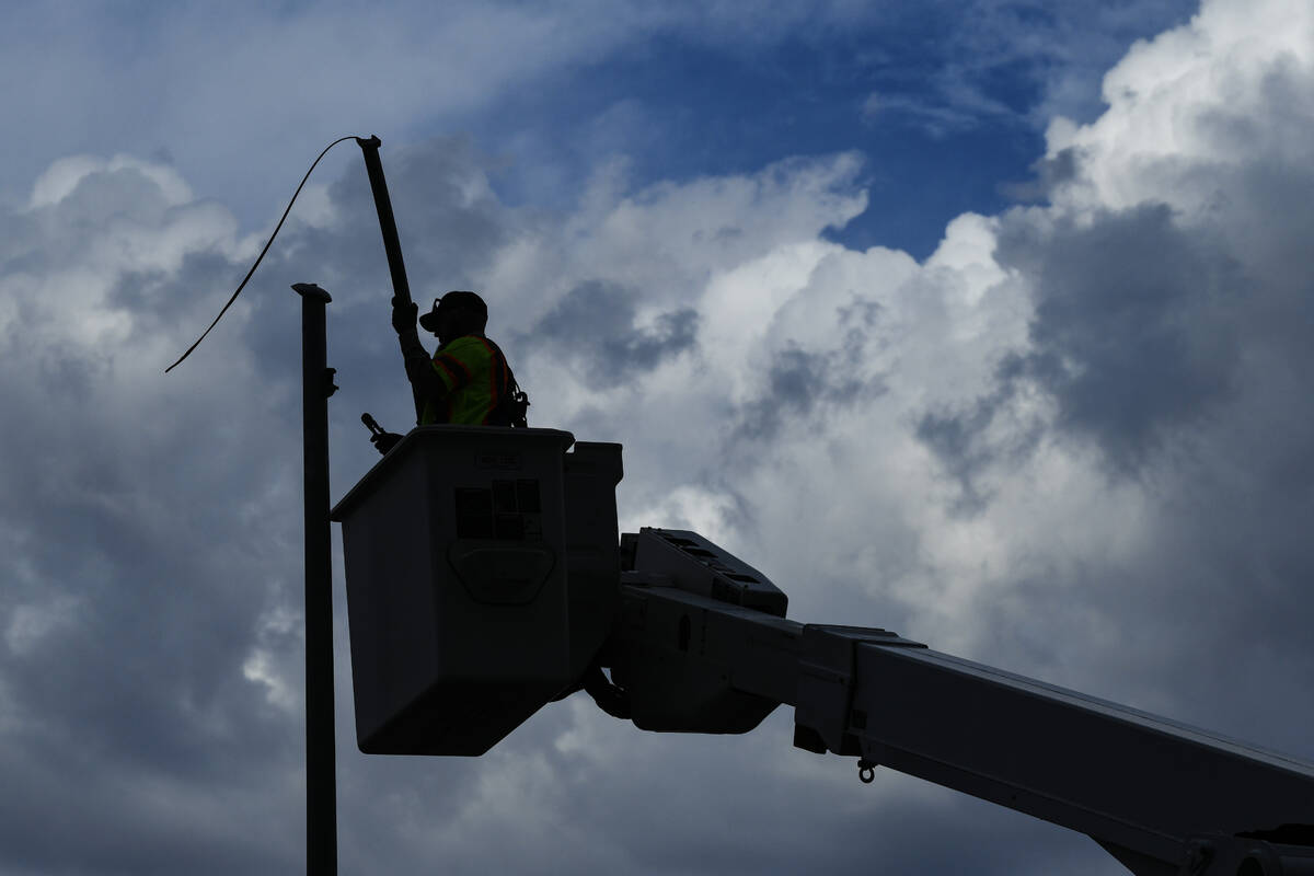 A worker removes a borken street light Wednesday, July 2, 2025, on Tropicana Avenue between McL ...