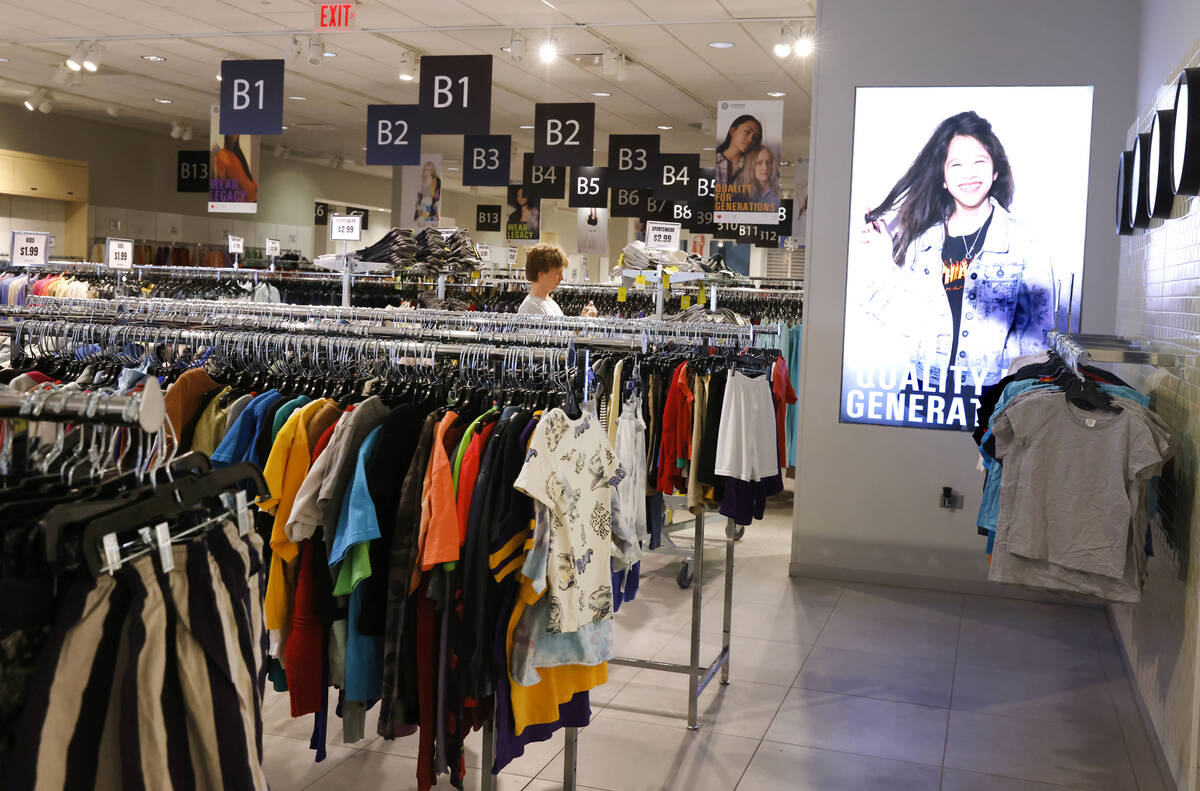 An employee hungs pre-owned clothes at Sanithrift at the Primm mall on Monday, June 16, 2025, i ...