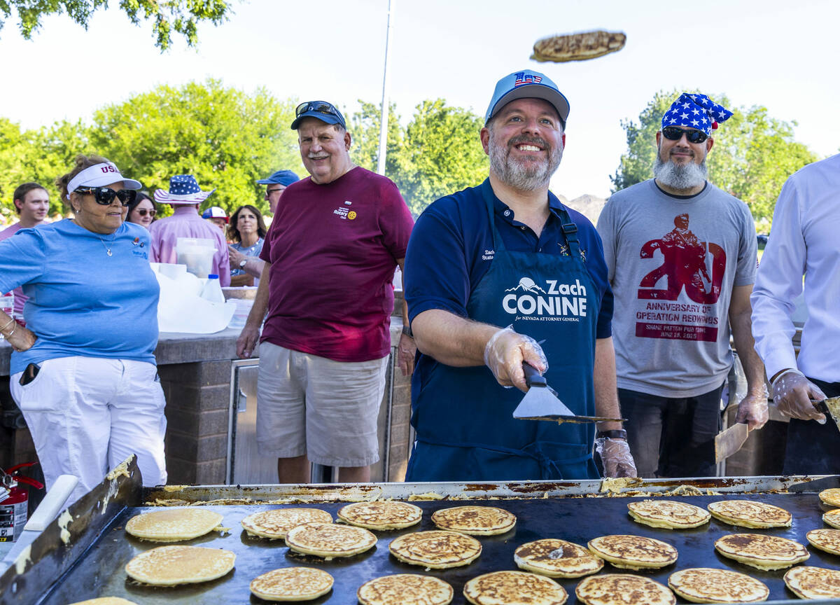 Nevada State Treasurer Zach Conine shows off his flipping skills as part of the pancake breakfa ...