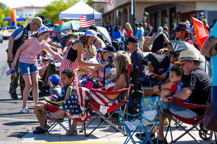 Flags are passed out by the American Legion Post 31 during the parade at the 77th Annual Dambor ...