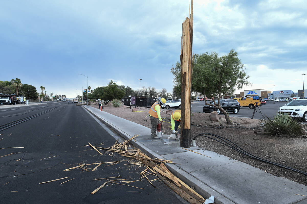 Workers cut out concrete to removed a downed power pole Wednesday, July 2, 2025, on Tropicana A ...
