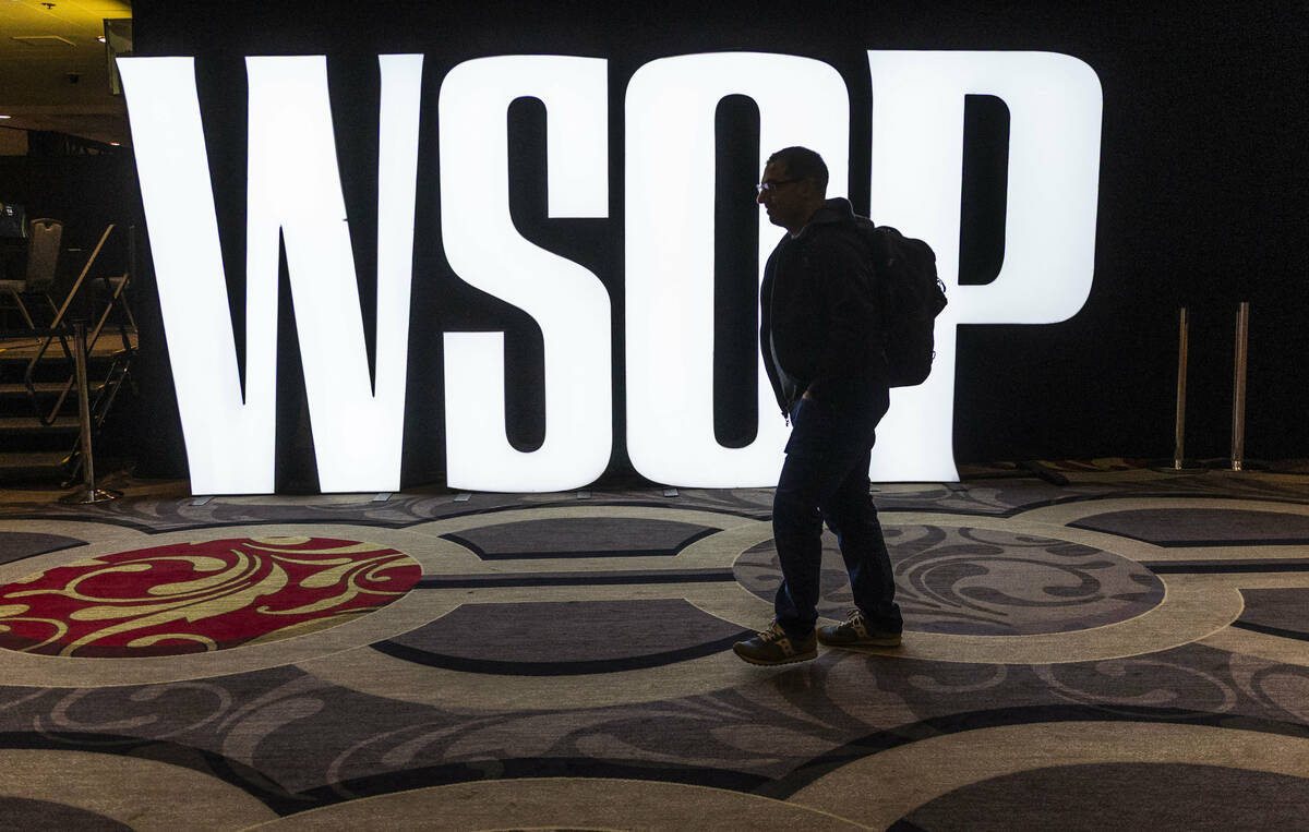 A player walks to his table past an illuminated sign during opening day of the WSOP Main Event ...