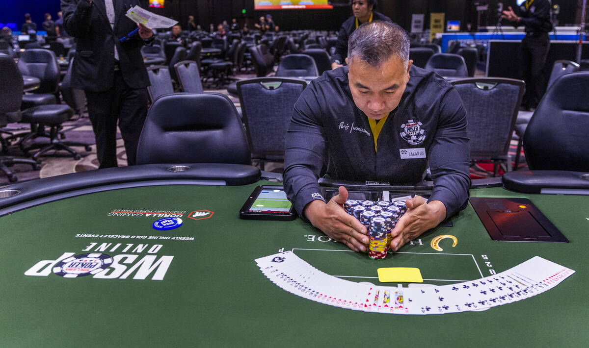 Dealer Rome Lazarus readies his table for players during opening day of the WSOP Main Event at ...