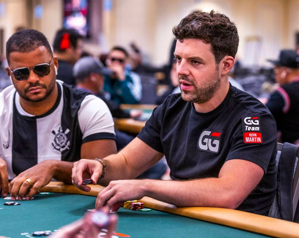 Professional poker player Kevin Martin confers with a dealer at his table during opening day of ...