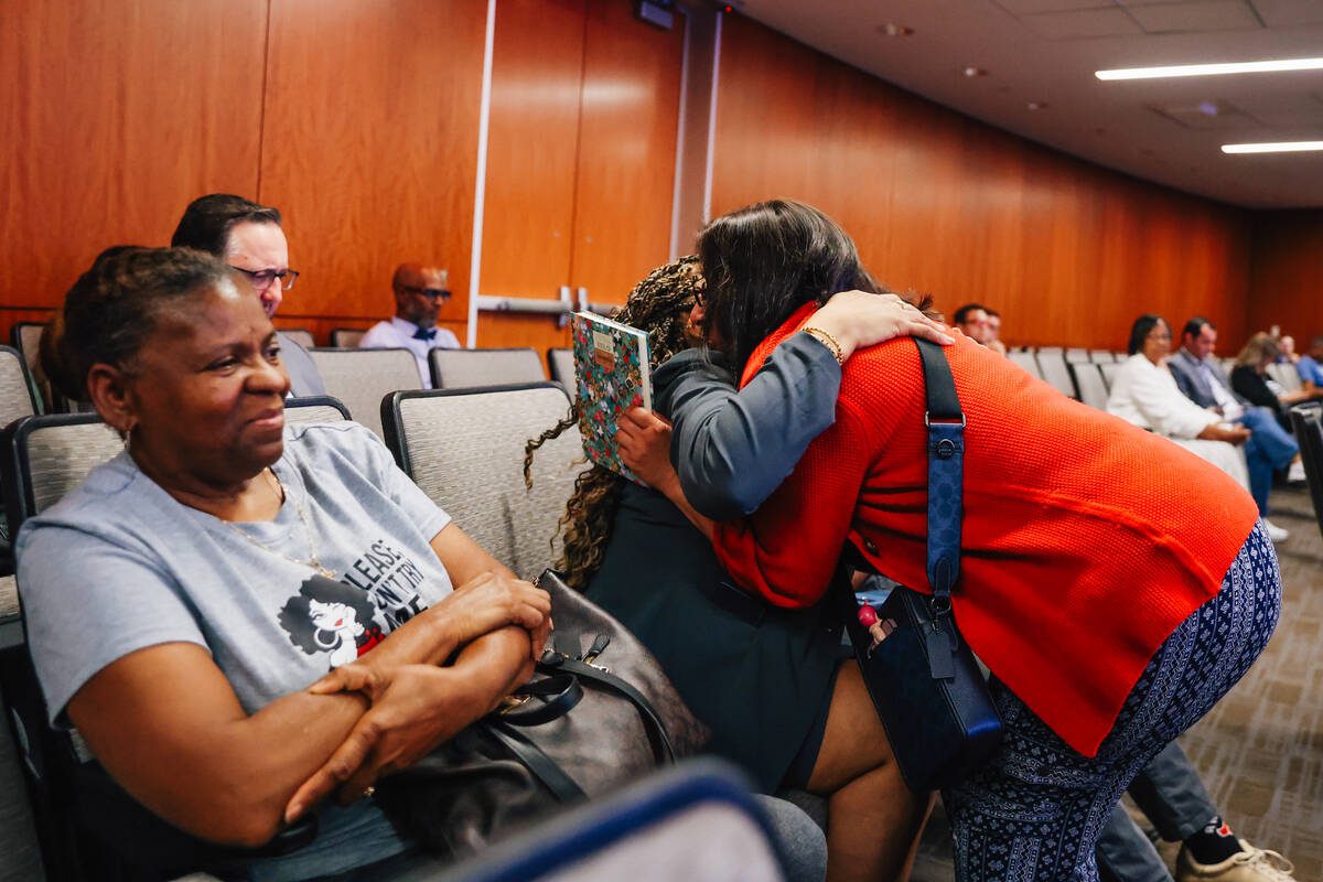 Nevada state senator Dina Neal, middle, receives a hug after speaking during a city council mee ...