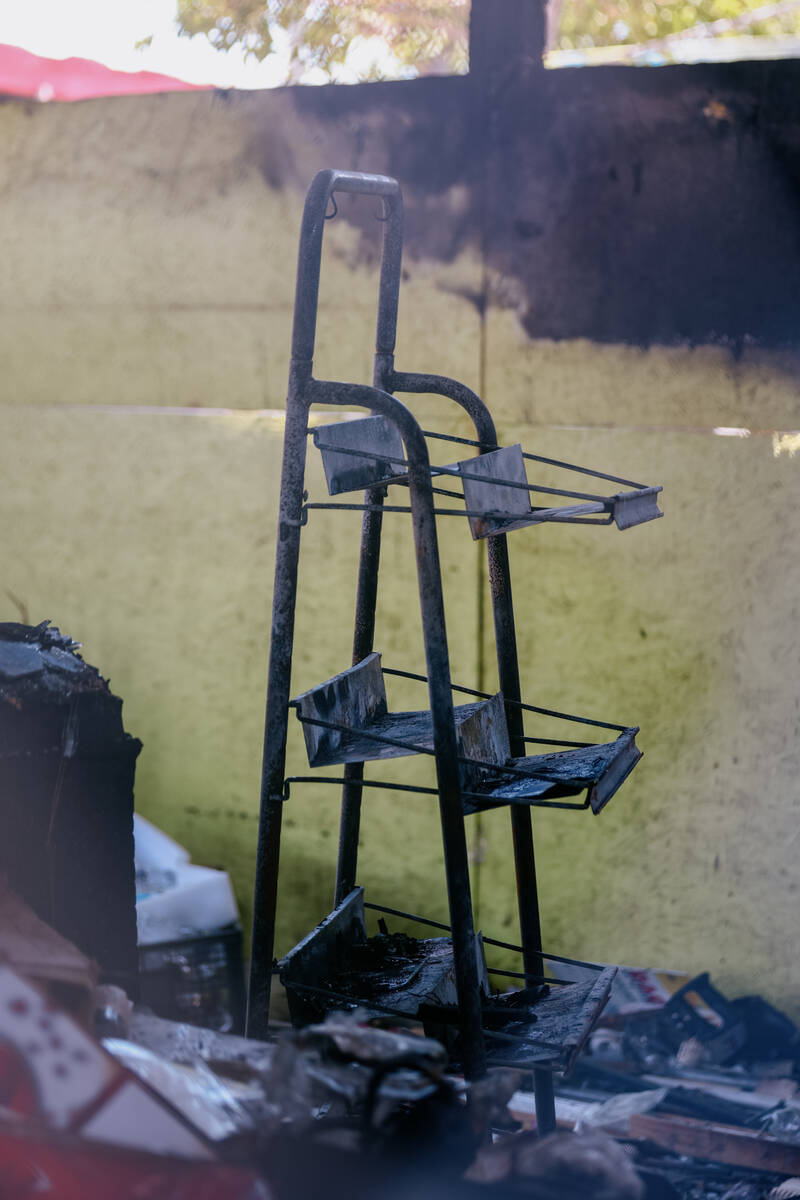 A blackened merchandise shelf sits in the remains of a burnt stall at Broadacres Marketplace on ...