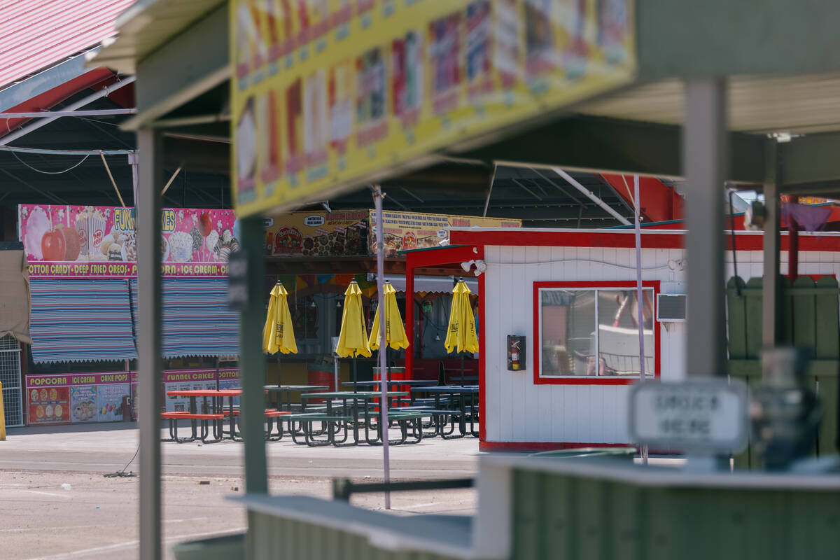 Empty picnic tables sit with their umbrellas closed in the food hall portion of Broadacres Mark ...