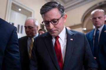 Speaker of the House Mike Johnson, R-La., walks behind his security detail through a crowd of r ...