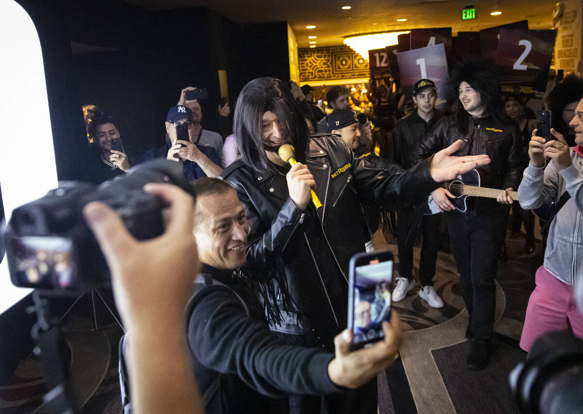 An eager fan records while greeting Phil Hellmuth, 17-time World Series of Poker champion, as h ...
