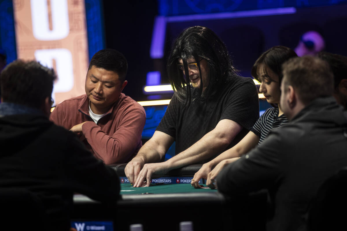 Phil Hellmuth, 17-time World Series of Poker champion, checks his cards after his grand entranc ...