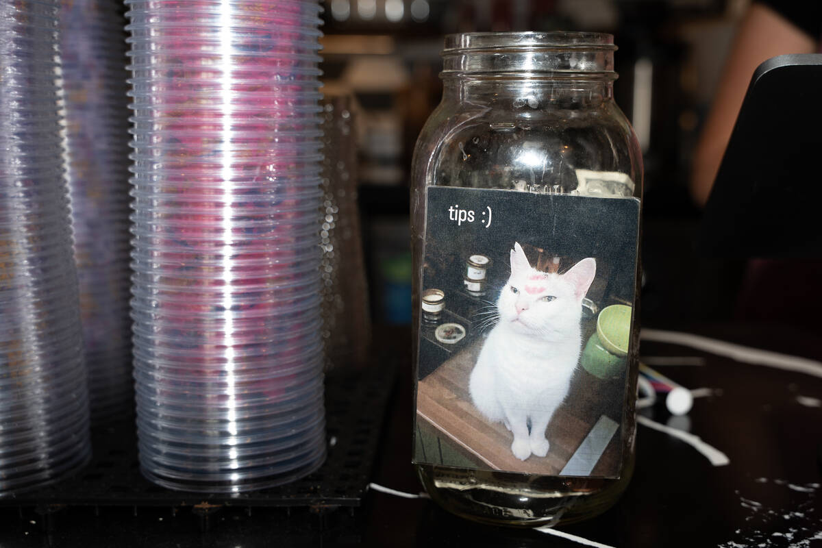 A tip jar decorated with a viral Twitter meme sits on the counter at Mothership Coffee on East ...
