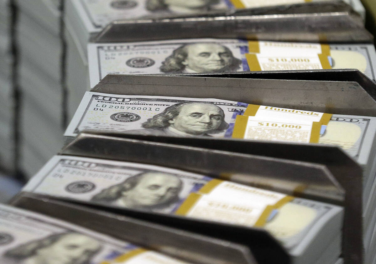 Cut stacks of $100 bills make their way down the line at the Bureau of Engraving and Printing W ...
