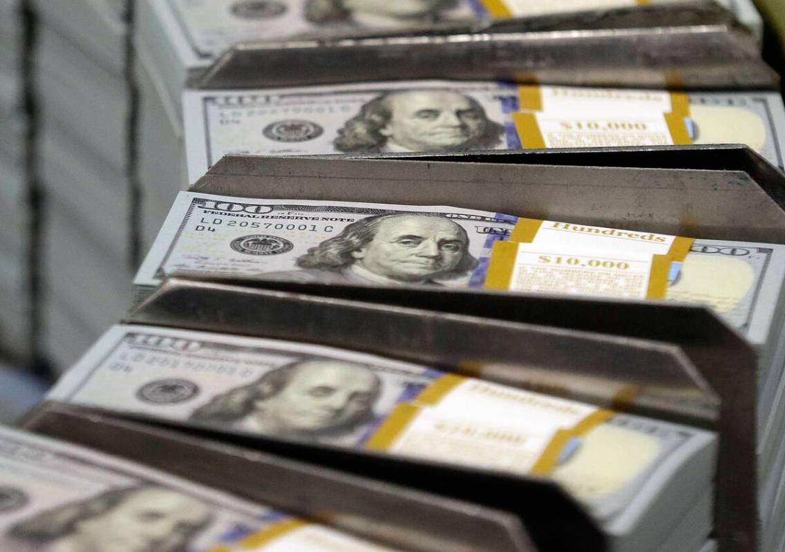Cut stacks of $100 bills make their way down the line at the Bureau of Engraving and Printing W ...