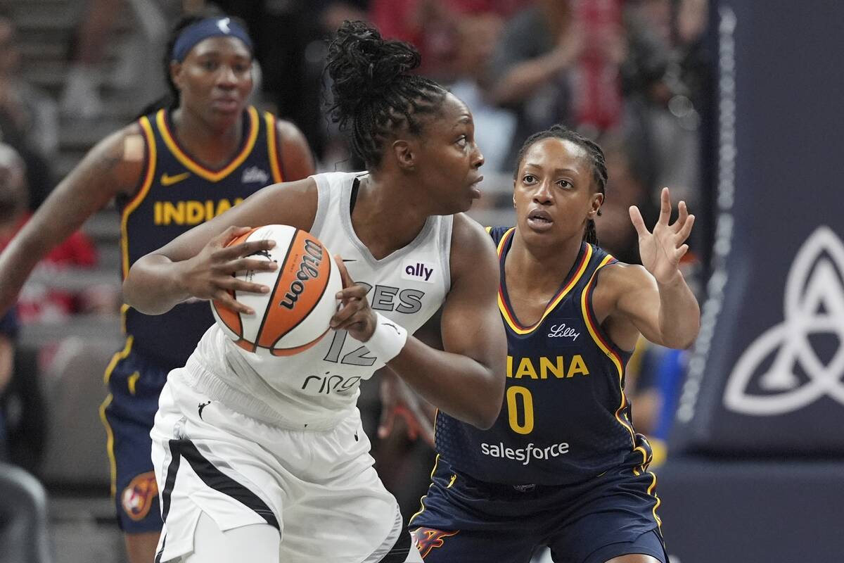 Las Vegas Aces' Chelsea Gray (12) is defended by Indiana Fever's Kelsey Mitchell (0) during the ...