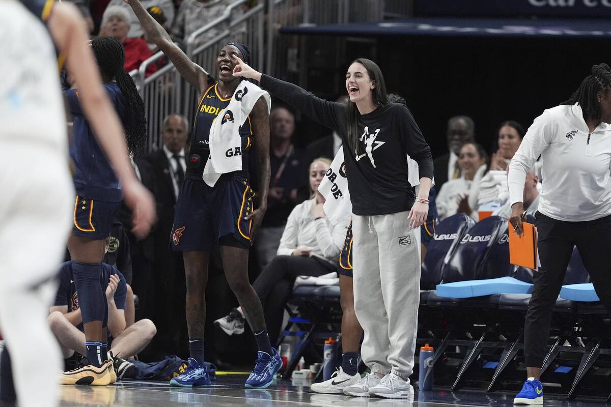 Indiana Fever's Caitlin Clark, right, cheers during the second half of a WNBA basketball game a ...