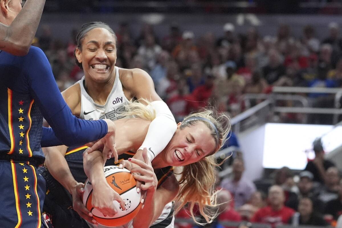 Indiana Fever's Lexie Hull, right, and Las Vegas Aces' A'ja Wilson battle for a loose ball duri ...