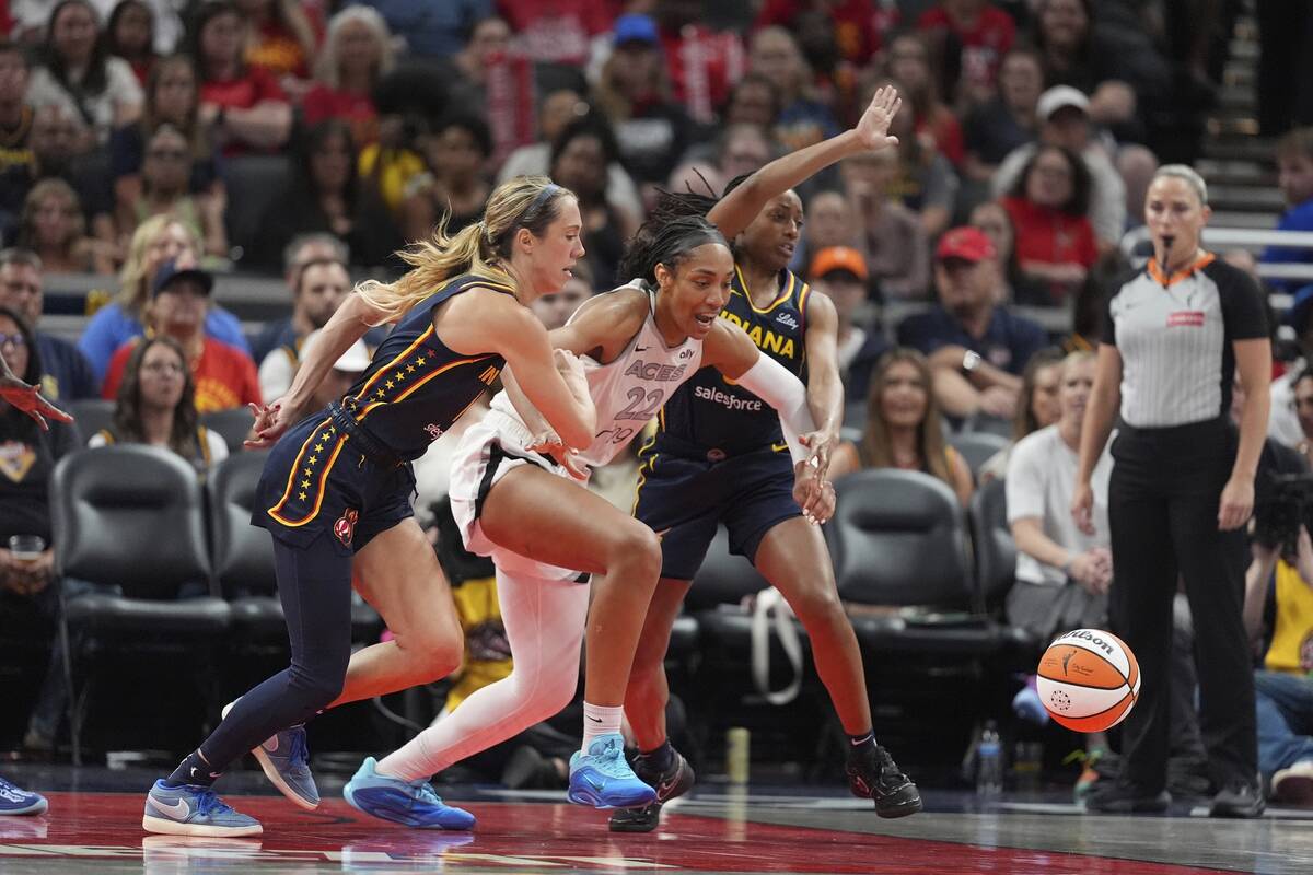 Las Vegas Aces' A'ja Wilson goes for a loose ball against Indiana Fever's Lexie Hull, left, and ...