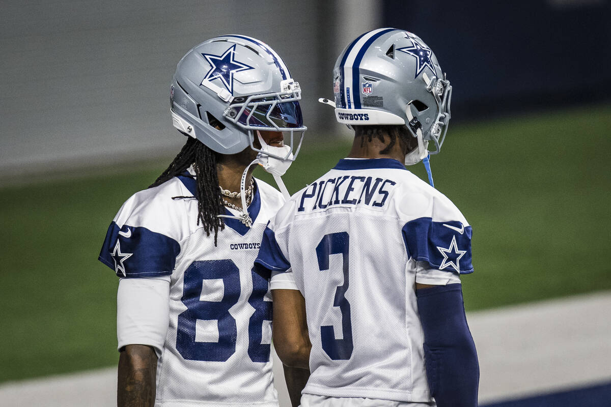 Dallas Cowboys' CeeDee Lamb and George Pickens (3) talk during practice at NFL football minicam ...